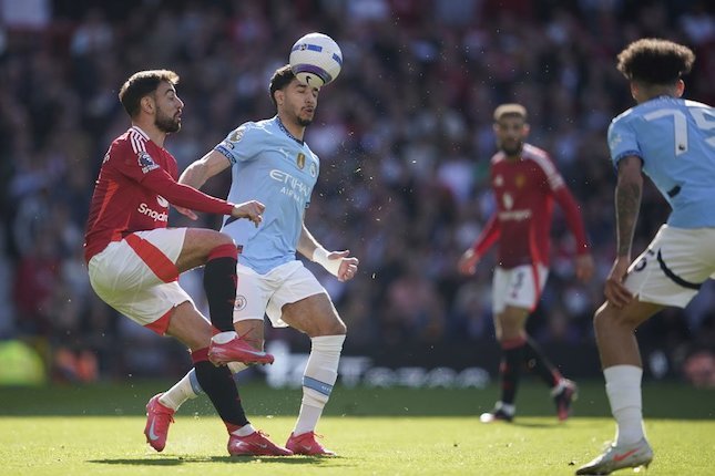 Duel Bruno Fernandes lawan Omar Marmoush di laga Man United vs Man City di Old Trafford, Minggu (06/4/2025). (c) AP Photo/Dave Thompson