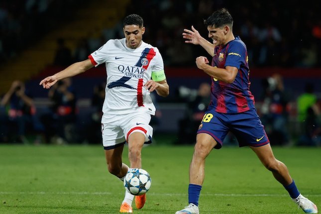 Achraf Hakimi berduel memperebutkan bola dengan Gerard Martin dalam laga Liga Champions antara Barcelona dan PSG