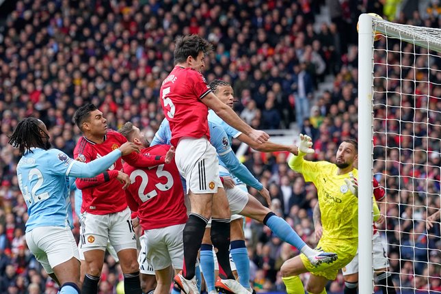 Harry Maguire menanduk bola di laga Manchester United vs Manchester City